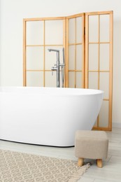 Beautiful white tub and ottoman in bathroom. Interior design