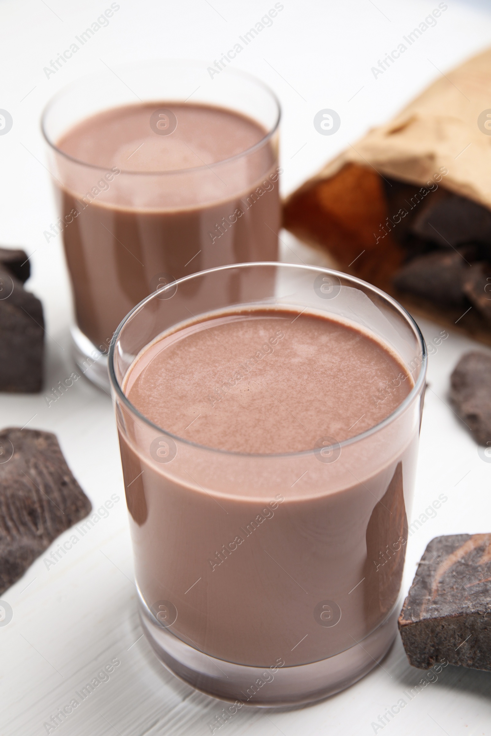 Photo of Delicious chocolate milk on white wooden table