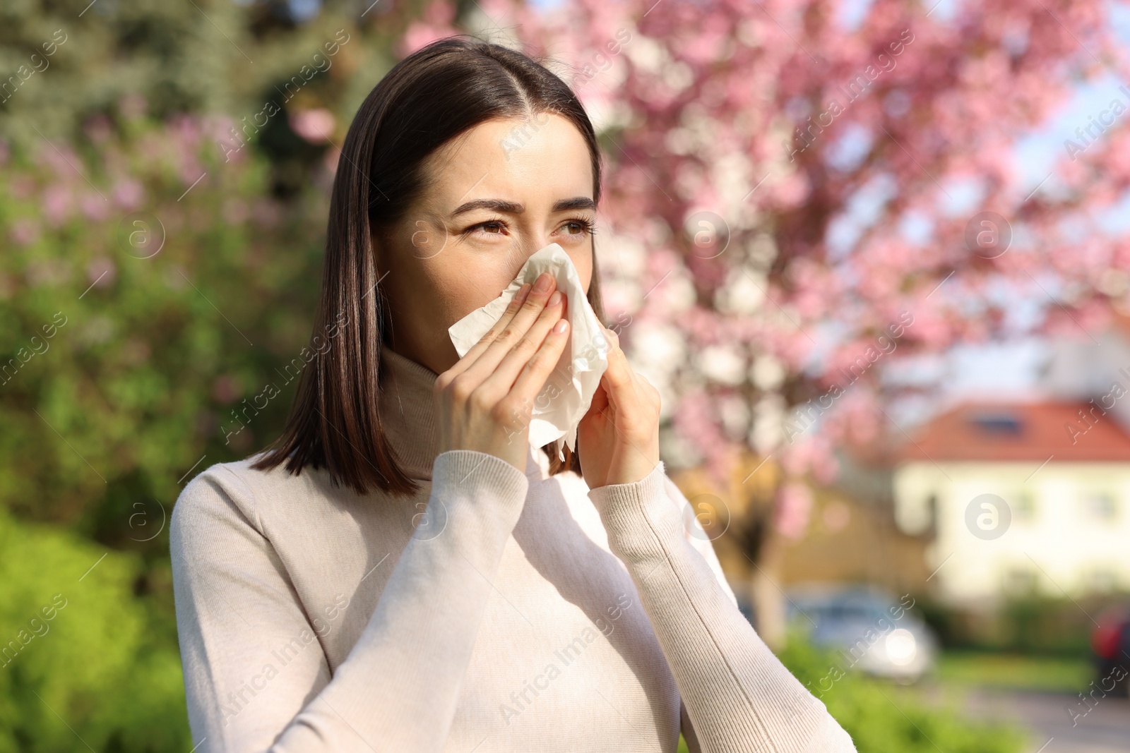 Photo of Woman with napkin suffering from seasonal allergy on spring day