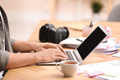 Photo of Professional journalist working with laptop in office, closeup