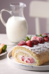 Delicious cake roll with strawberries and cream on light gray table