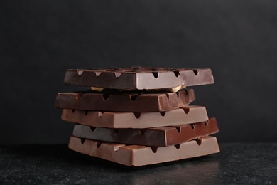 Photo of Delicious milk and dark chocolate bars on table