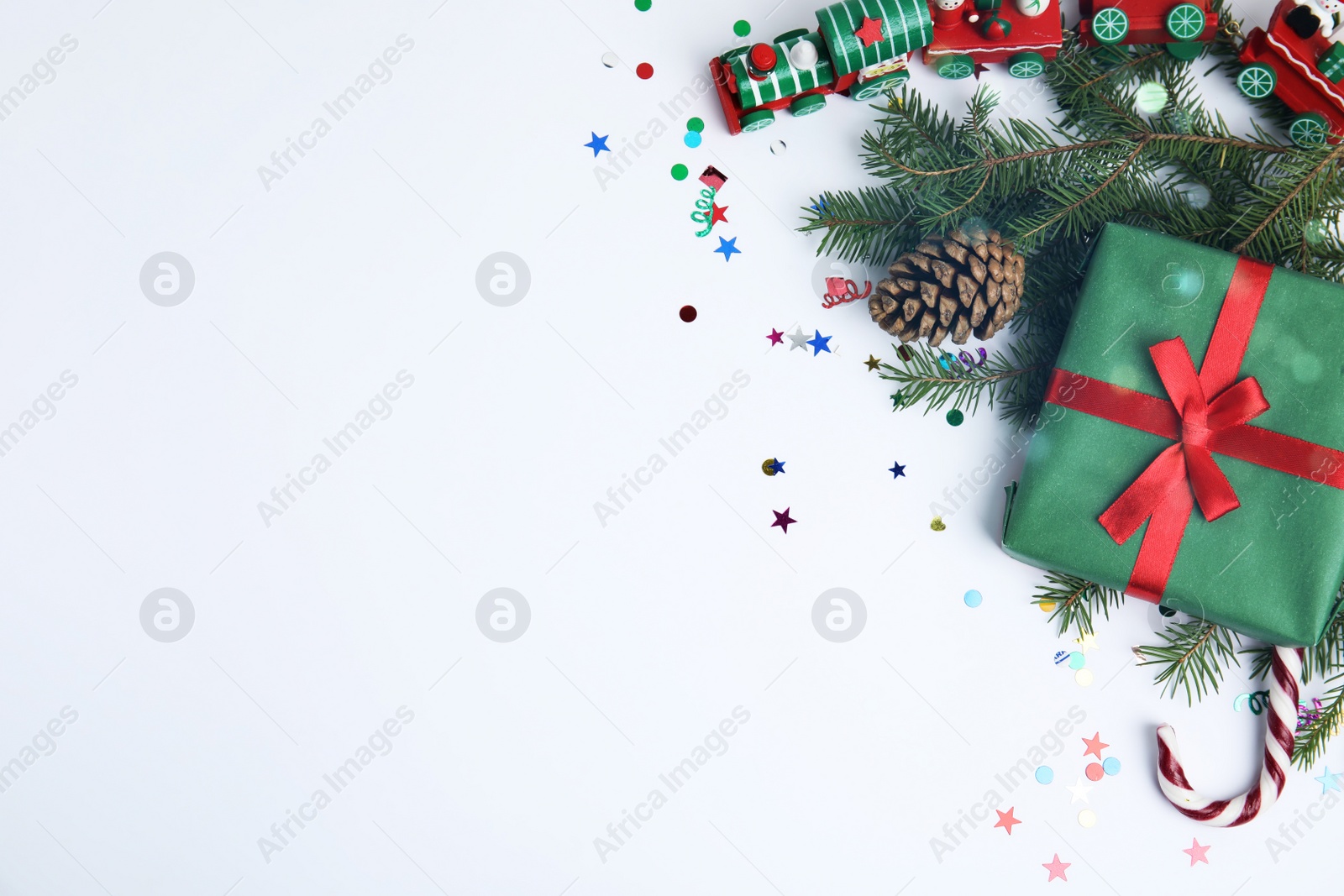 Photo of Christmas greeting card with space for text. Flat lay composition of fir tree branches and festive decor on white background