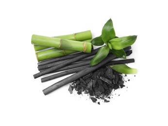 Photo of Fresh bamboo and charcoal on white background, top view