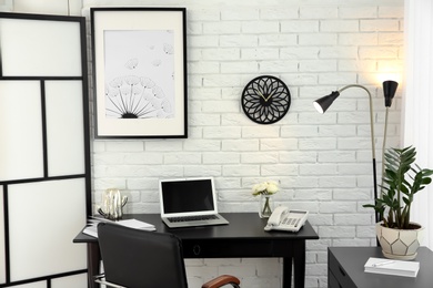 Stylish workplace interior with laptop on table