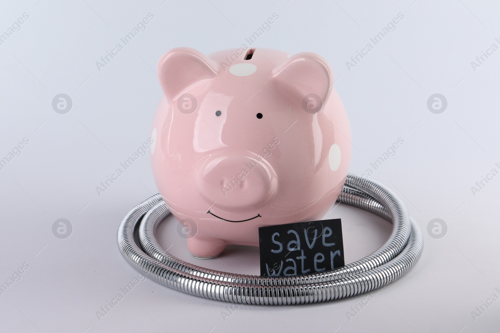 Photo of Water scarcity concept. Card with phrase Save Water, piggy bank and shower hose isolated on white