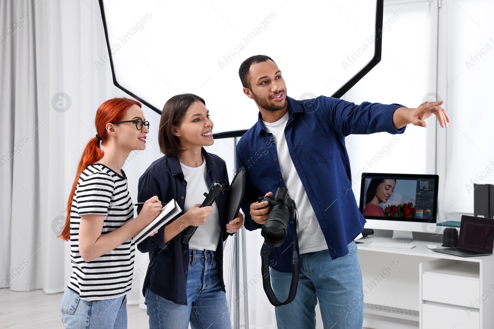 Photo of Young professional photographers working in modern photo studio