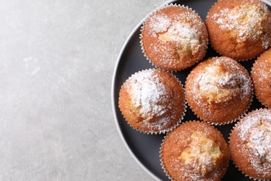 Photo of Delicious sweet muffins on light grey textured table, top view. Space for text