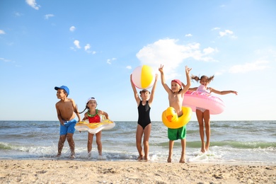 Cute children enjoying sunny day at beach. Summer camp