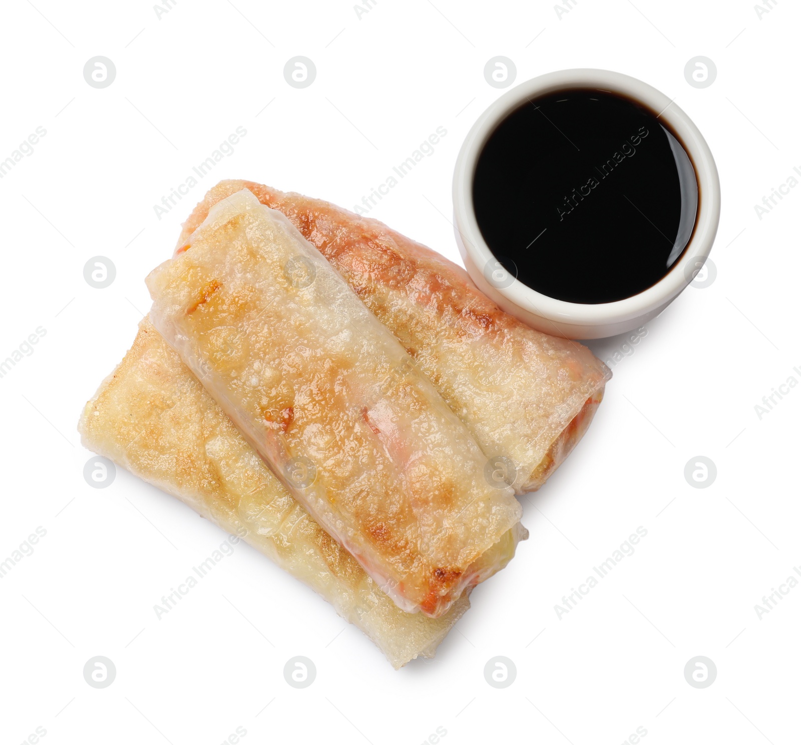 Photo of Delicious fried spring rolls and sauce isolated on white, top view