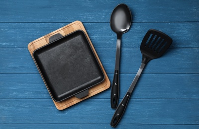 Set of modern cooking utensils on blue wooden table, flat lay