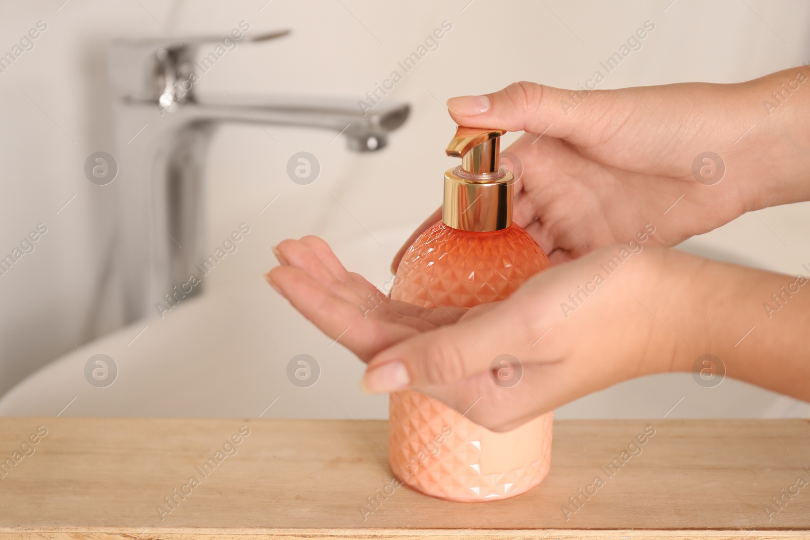 Photo of Woman using liquid soap in bathroom, closeup