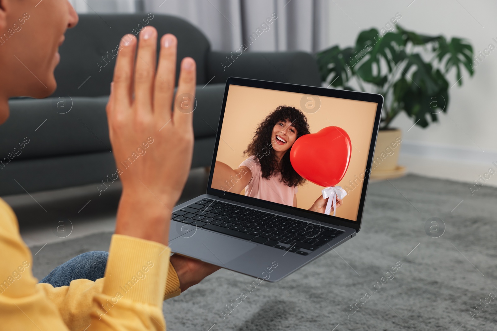 Image of Long distance love. Man having video chat with his girlfriend via laptop at home, closeup