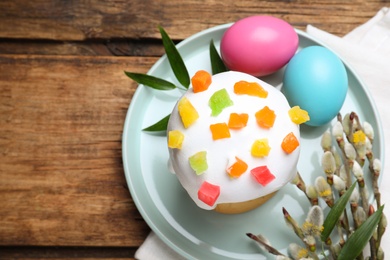 Photo of Beautiful Easter cake and painted eggs on wooden table, flat lay