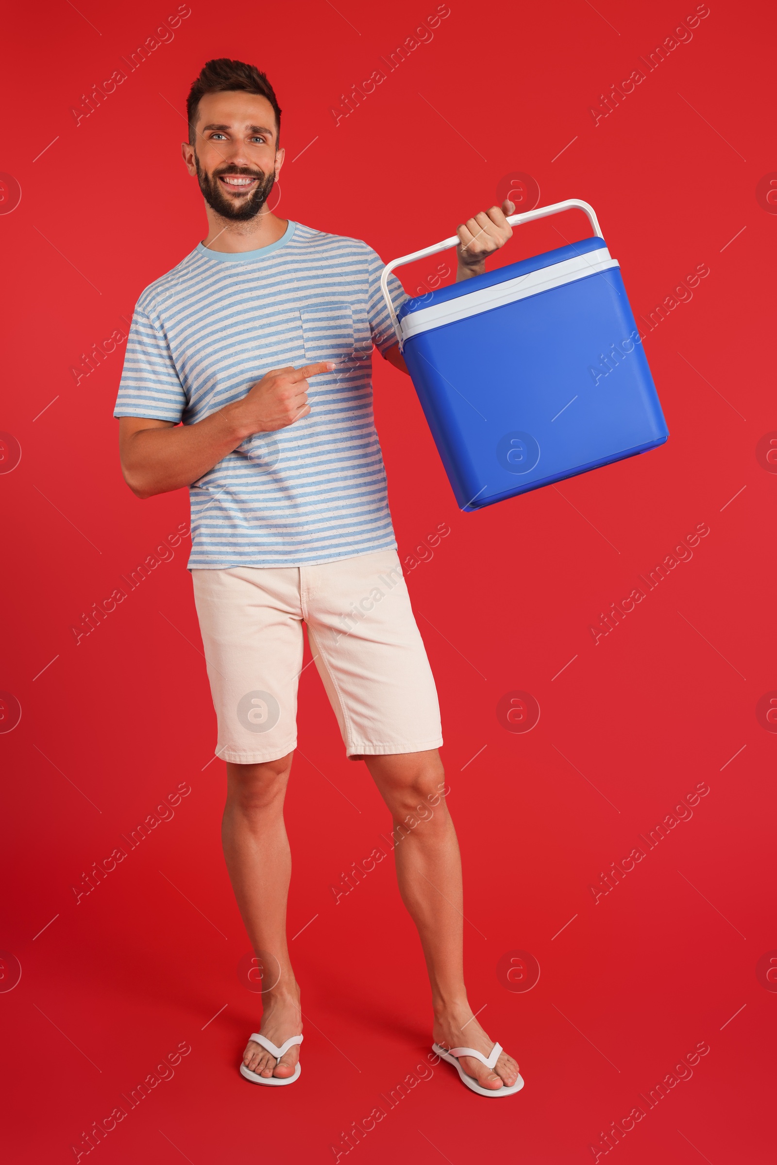 Photo of Happy man with cool box on red background