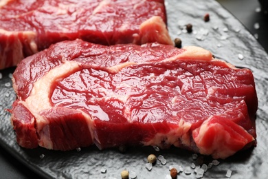 Fresh marbled meat steaks on slate board, closeup