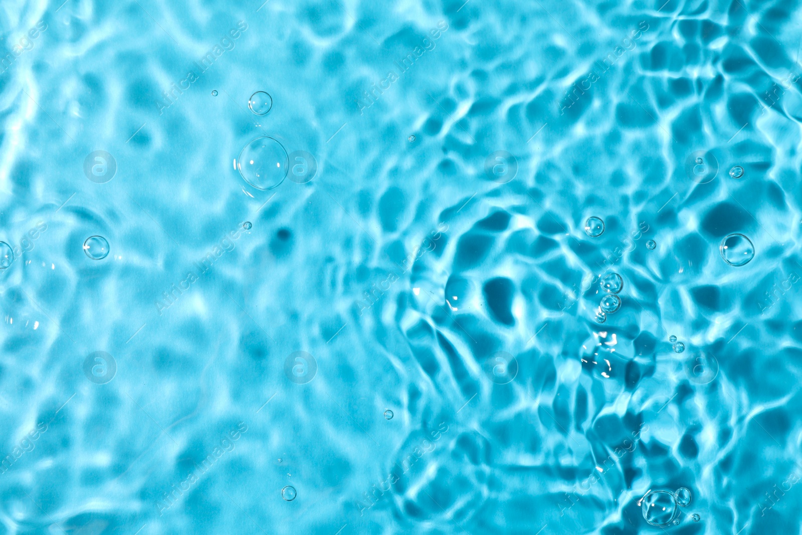 Photo of Closeup view of water with rippled surface on light blue background