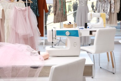 Sewing machine and equipment on table in dressmaking workshop