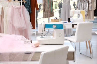 Photo of Sewing machine and equipment on table in dressmaking workshop