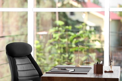 Table with scales of justice in lawyer's office