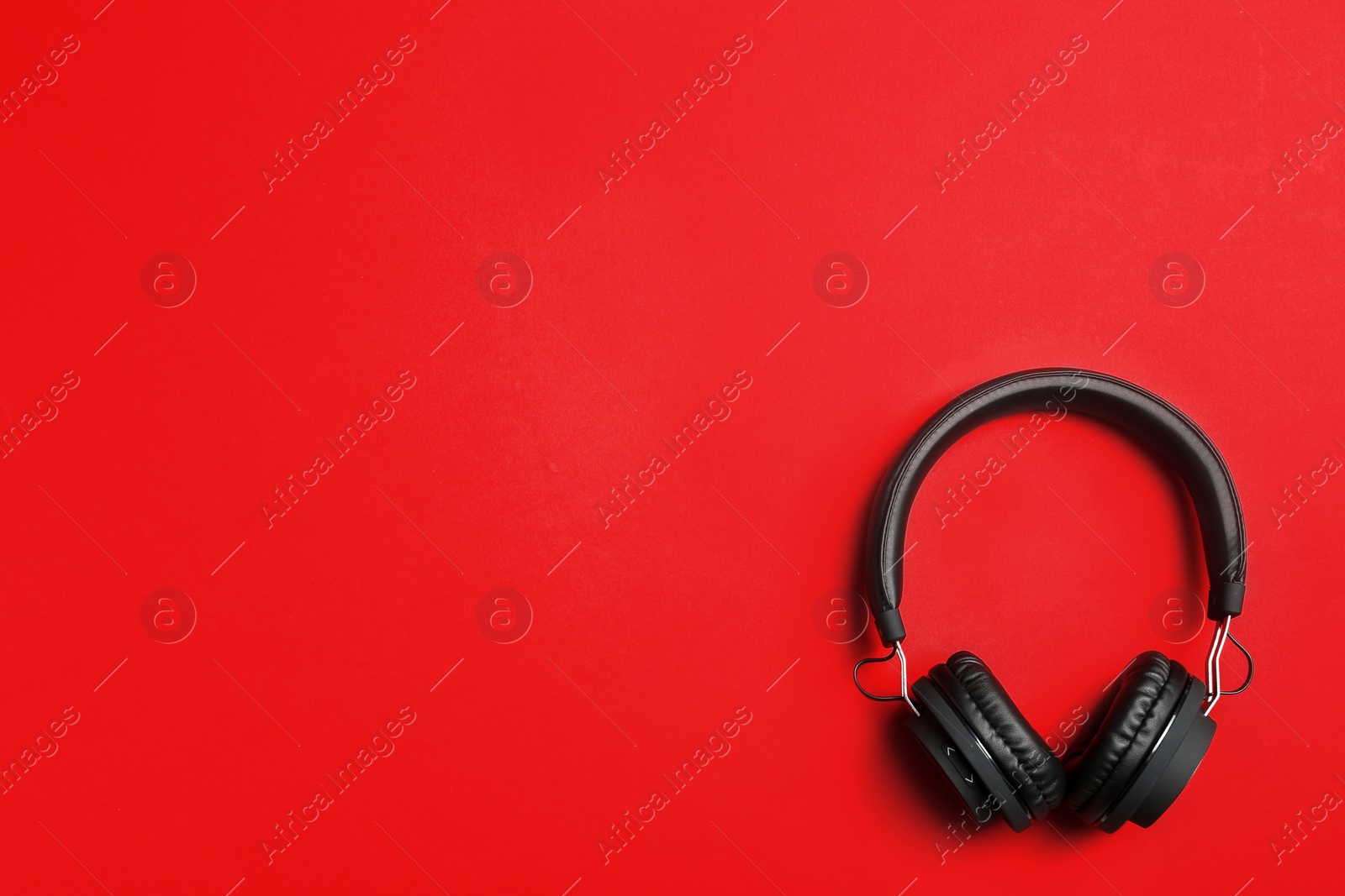 Photo of Stylish headphones on color background, top view. Space for text