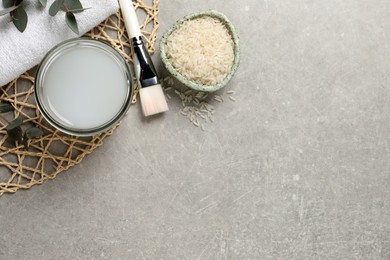 Flat lay composition with homemade natural rice water on light table. Space for text