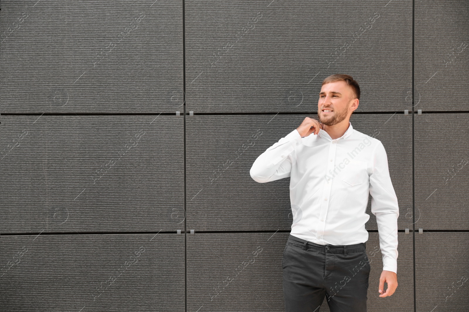 Photo of Portrait of handsome young man leaning to wall outdoors, space for text