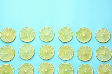 Fresh juicy lime slices on light blue background, flat lay. Space for text