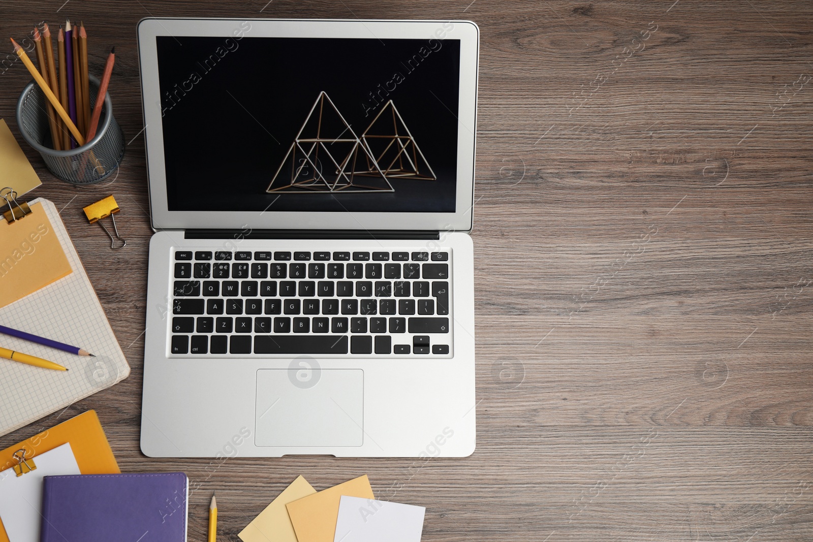 Photo of Modern laptop and supplies in wooden table, above view. Space for text