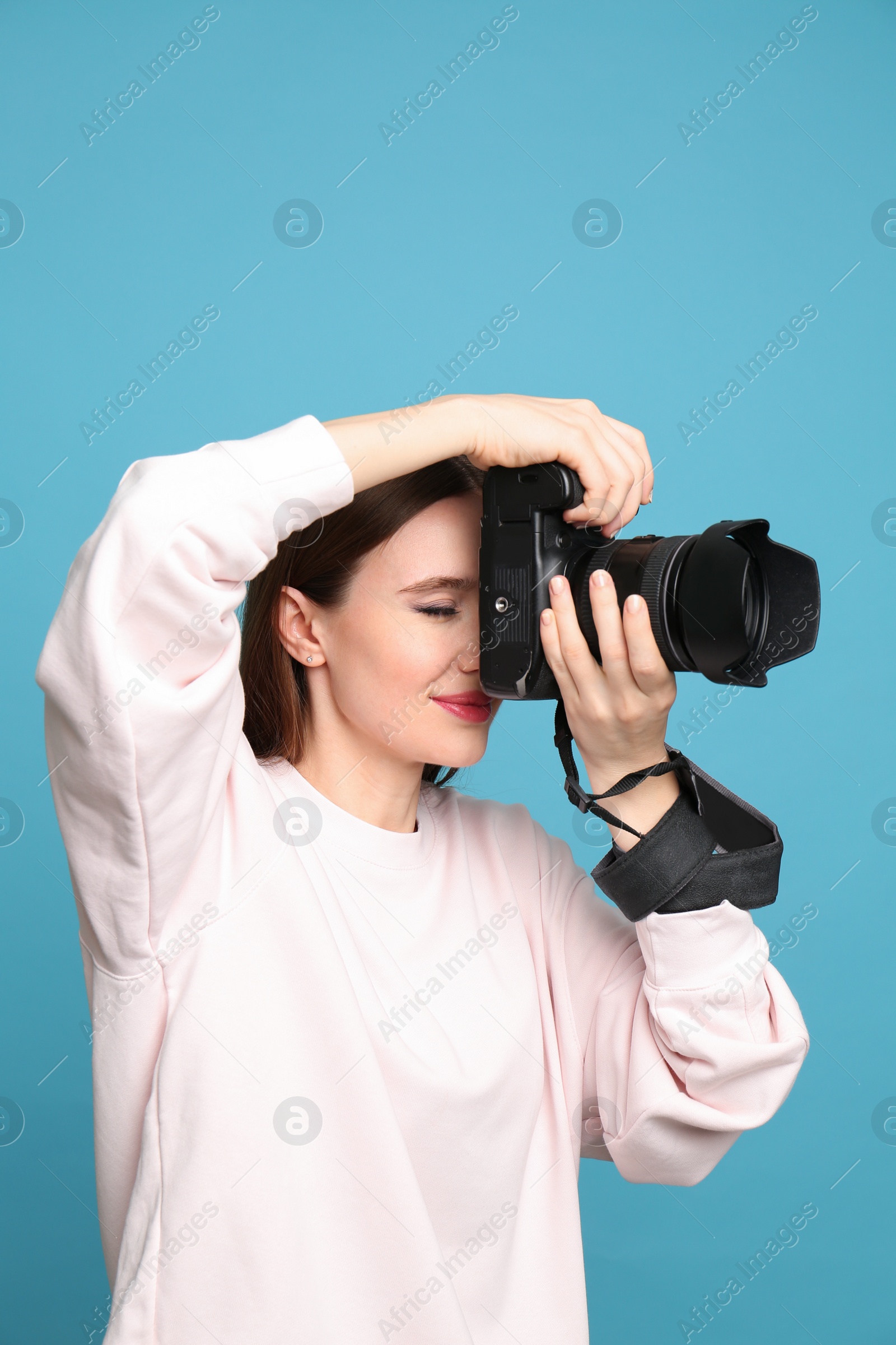 Photo of Professional photographer taking picture on light blue background