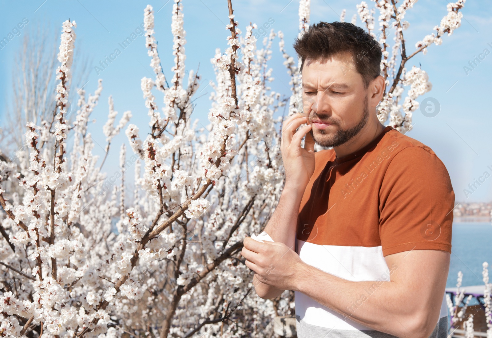 Photo of Man suffering from seasonal allergy outdoors, space for text