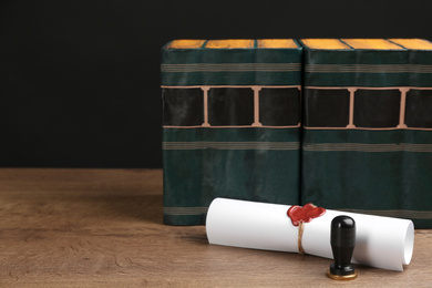 Photo of Notary's public pen, document with wax stamp and books on wooden table