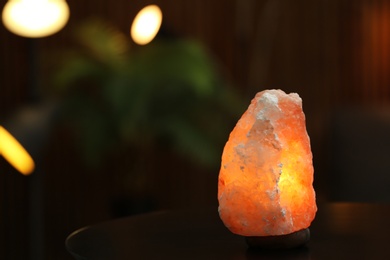 Himalayan salt lamp on table indoors, space for text