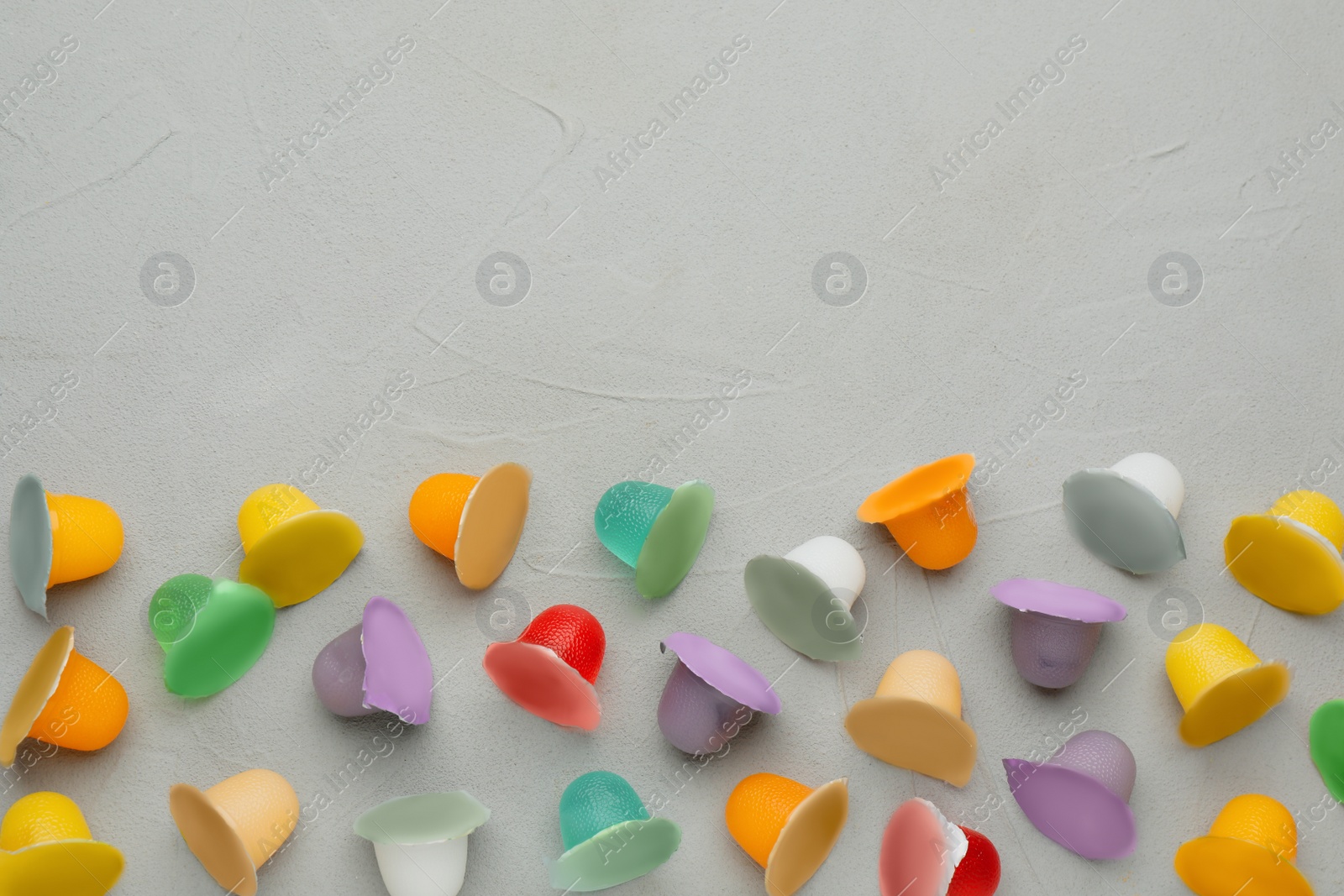 Photo of Tasty bright jelly cups on light table, flat lay. Space for text