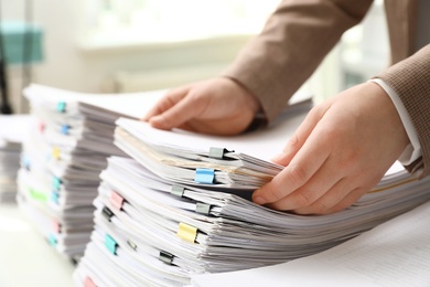 Photo of Woman working with documents at table in office, closeup