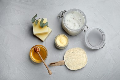 Photo of Flat lay composition with beeswax and cosmetic products on light grey stone table