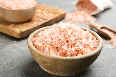 Pink himalayan salt in wooden bowl on grey table
