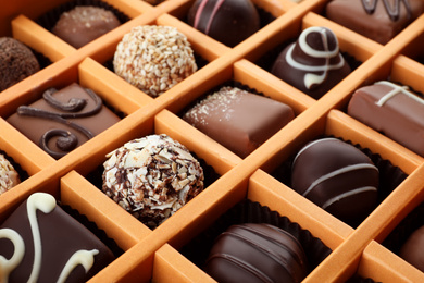 Photo of Box with different chocolate candies as background, closeup