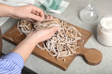 Woman making soba at table in kitchen, closeup