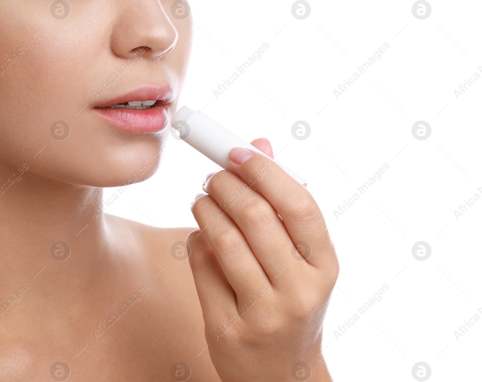 Photo of Young woman with cold sore applying lip balm against white background, closeup