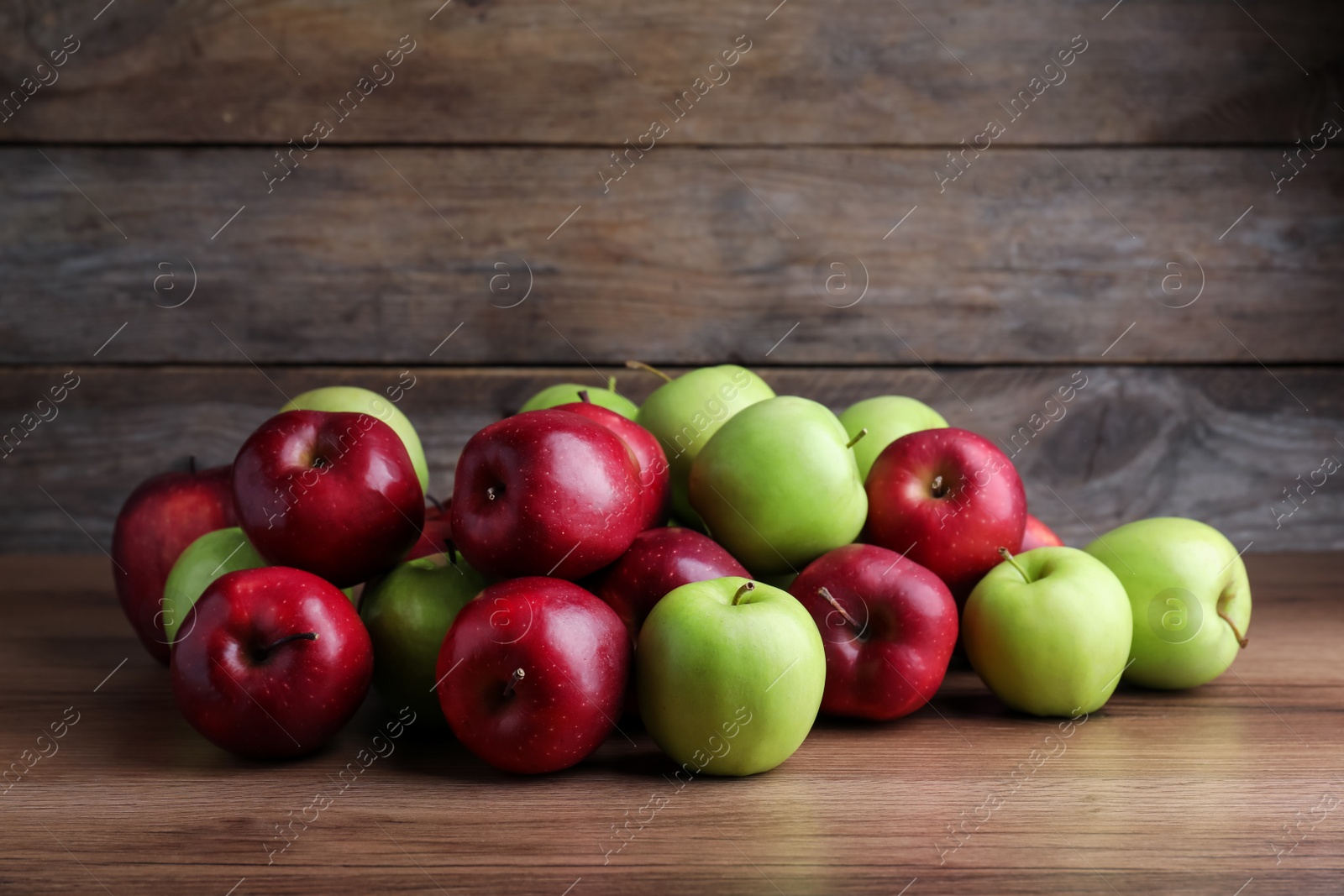 Photo of Fresh ripe red and green apples on wooden table