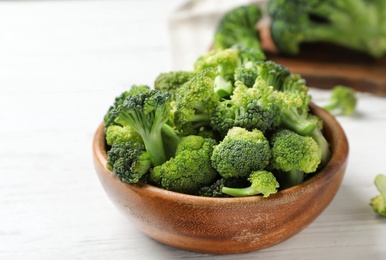 Bowl with fresh green broccoli on table