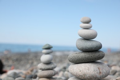 Photo of Stack of stones on beach against blurred background, closeup. Space for text