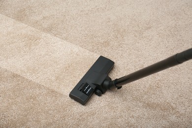 Image of Vacuuming dirty beige carpet. Clean area after using device, closeup