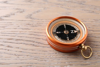 Photo of One compass on wooden table, space for text