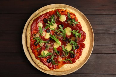 Photo of Pita pizza with cheese, olives, mushrooms and arugula on wooden table, top view