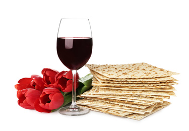 Passover matzos, glass of wine and flowers on white background. Pesach celebration