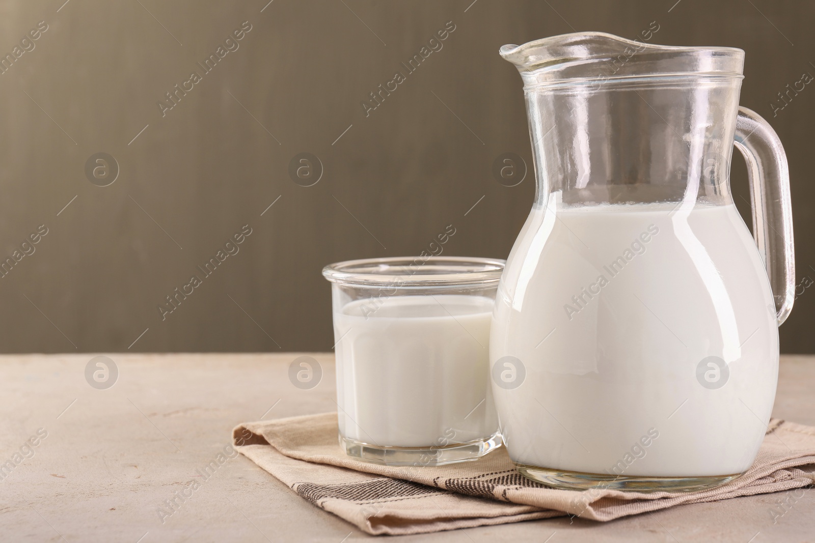 Photo of Glassware with tasty milk on light table, space for text