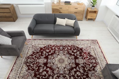 Photo of Cozy room interior with stylish furniture and soft carpet with beautiful pattern, view from above
