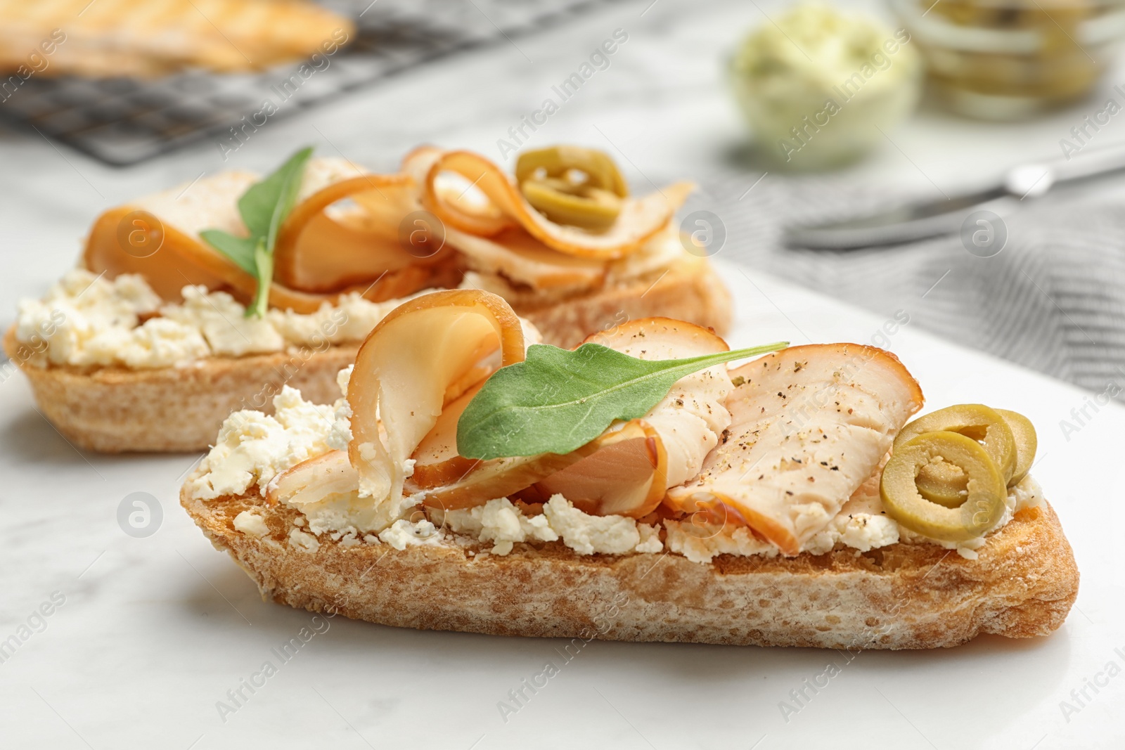 Photo of Board with delicious chicken bruschettas on table, closeup